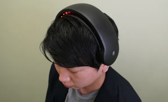 ヘルメット型の薄毛治療器「ヘアビーム」をかぶる男性